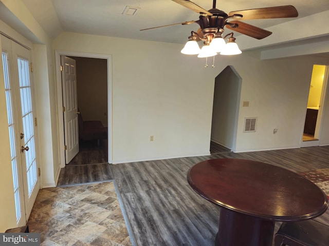 interior space featuring vaulted ceiling, baseboards, a ceiling fan, and visible vents