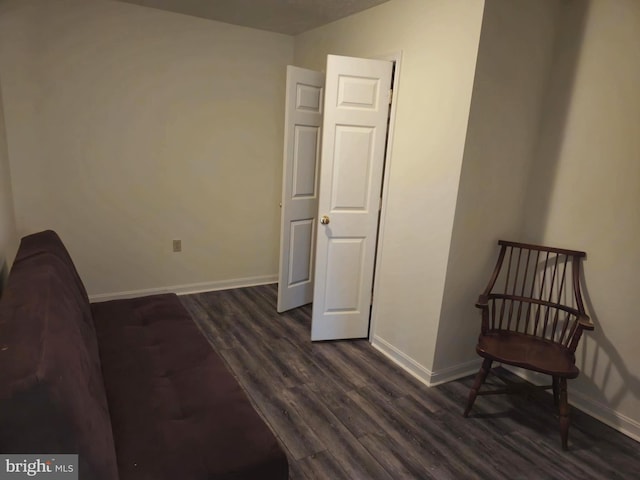 unfurnished room featuring baseboards and dark wood-type flooring
