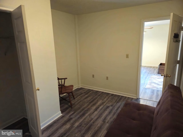 sitting room with baseboards and dark wood-style floors