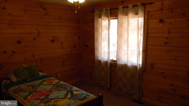 bedroom featuring wooden walls