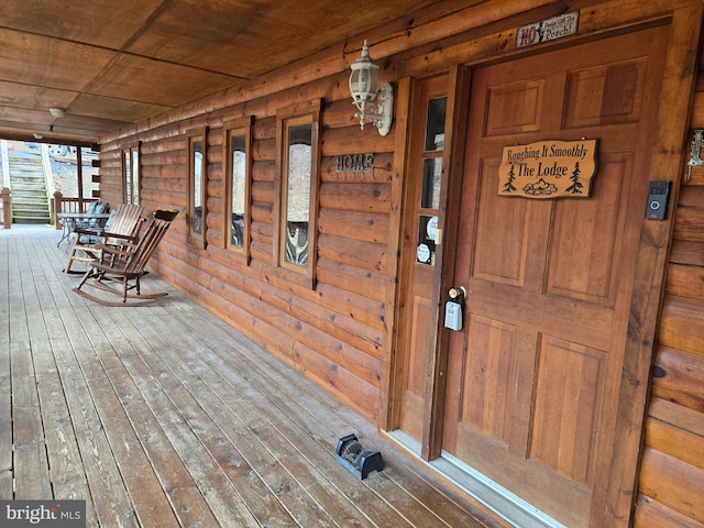 view of exterior entry featuring covered porch