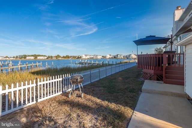 view of yard featuring a deck with water view and a dock