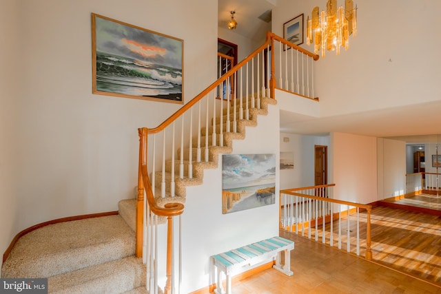 37763 Lagoon Ln, Ocean View, DE 19970 - stairway featuring a chandelier, a high ceiling, and baseboards