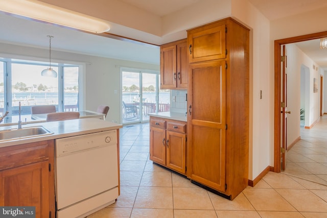 kitchen featuring dishwasher, light tile patterned flooring, sink, and hanging light fixtures