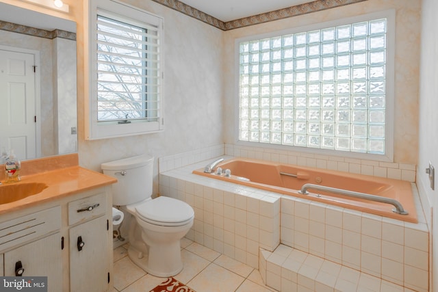 bathroom with tile patterned floors, vanity, toilet, and tiled tub