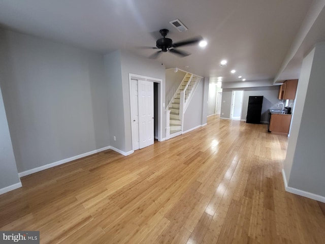 unfurnished living room featuring ceiling fan and light wood-type flooring