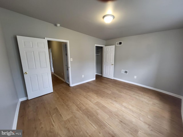 unfurnished bedroom with light hardwood / wood-style flooring and a closet