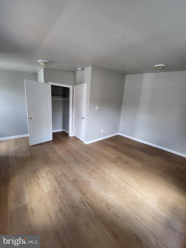 unfurnished bedroom featuring a closet and hardwood / wood-style floors