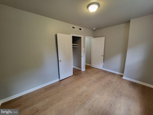 unfurnished bedroom featuring a closet and light hardwood / wood-style floors