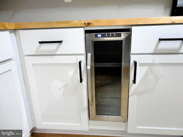 interior details with white cabinetry and beverage cooler