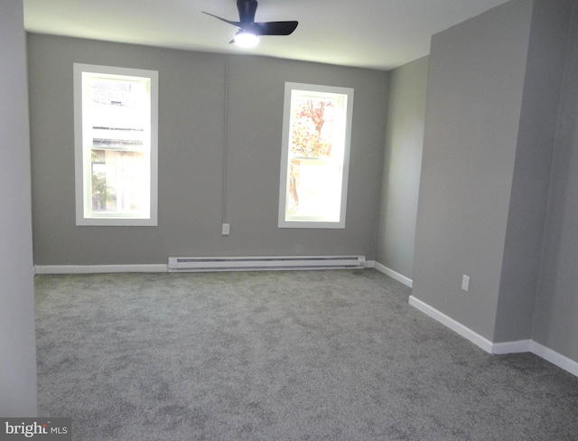 empty room featuring a healthy amount of sunlight, light colored carpet, and a baseboard radiator