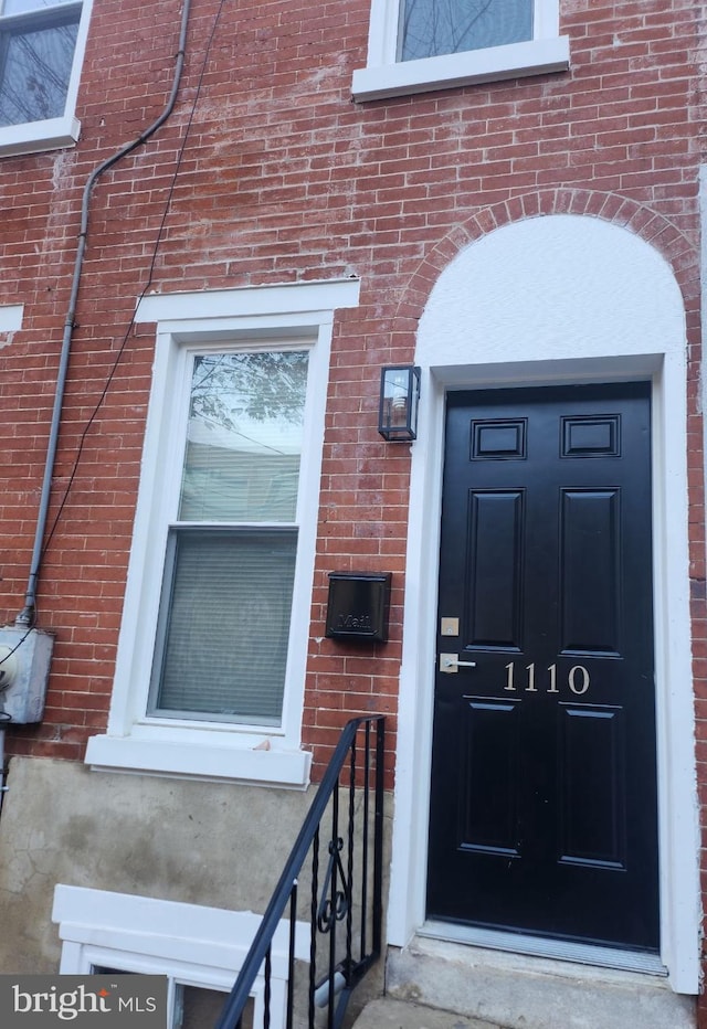 entrance to property featuring brick siding
