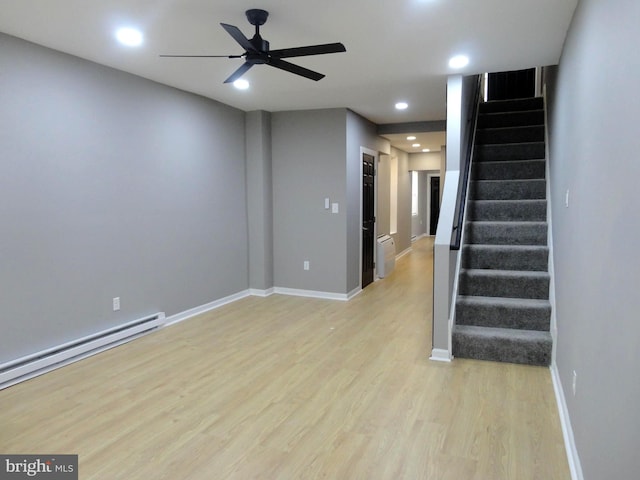 unfurnished room featuring light hardwood / wood-style floors, baseboard heating, and ceiling fan