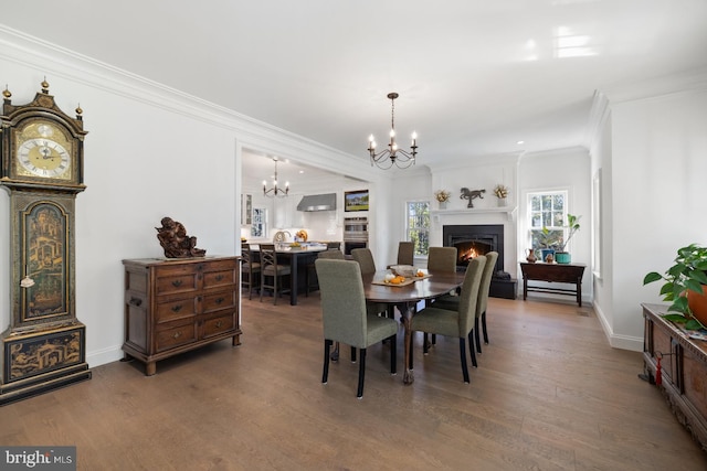 dining area featuring ornamental molding, hardwood / wood-style flooring, and an inviting chandelier