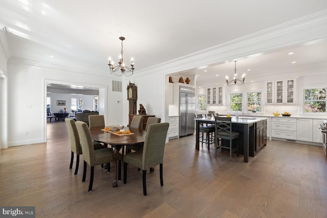 dining space featuring crown molding, a chandelier, and wood-type flooring