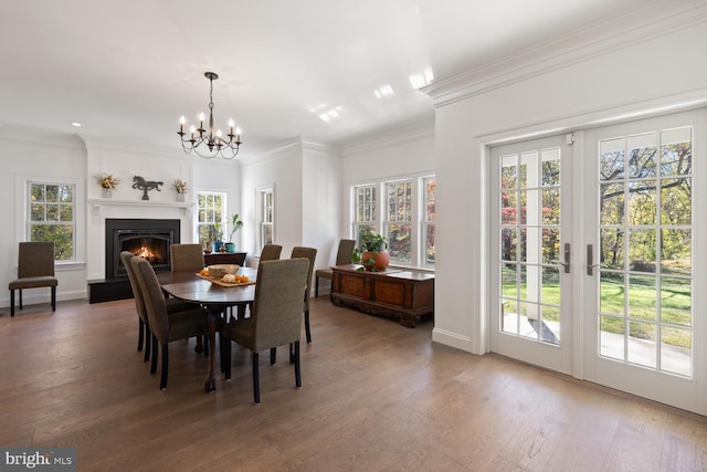 dining room featuring ornamental molding, hardwood / wood-style floors, a healthy amount of sunlight, and a chandelier