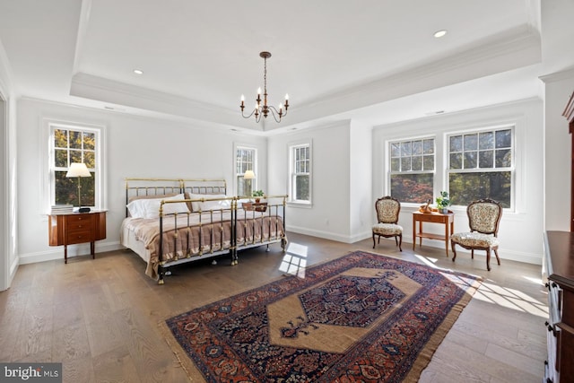 bedroom featuring hardwood / wood-style flooring, a chandelier, and a raised ceiling