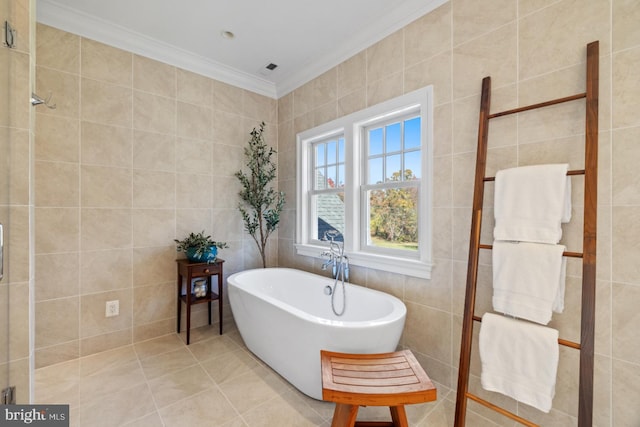 bathroom with a bath, tile patterned floors, tile walls, and ornamental molding