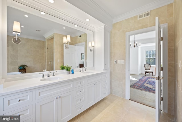 bathroom featuring tile walls, ornamental molding, vanity, an enclosed shower, and tile patterned flooring