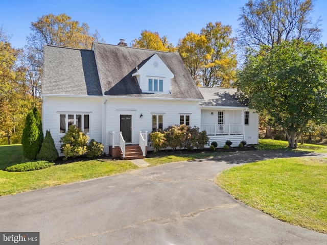 new england style home featuring a front yard