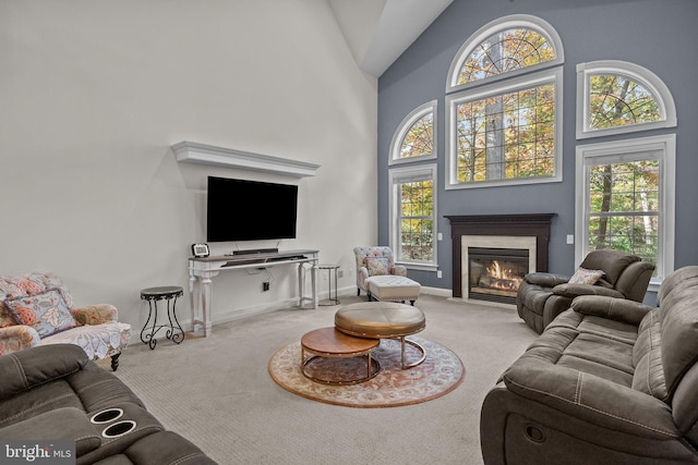 carpeted living room with a healthy amount of sunlight and high vaulted ceiling