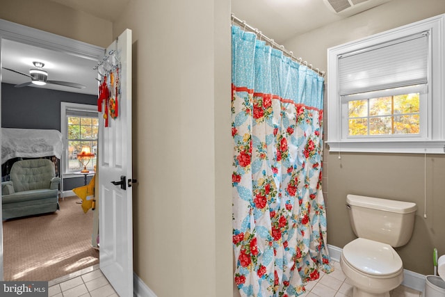 bathroom with tile patterned floors, a shower with shower curtain, toilet, and ceiling fan