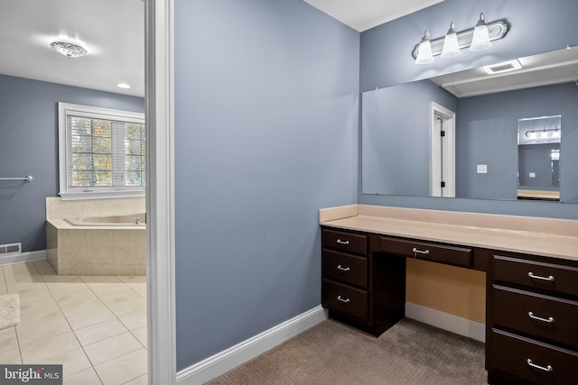 bathroom with vanity, tile patterned floors, and tiled bath