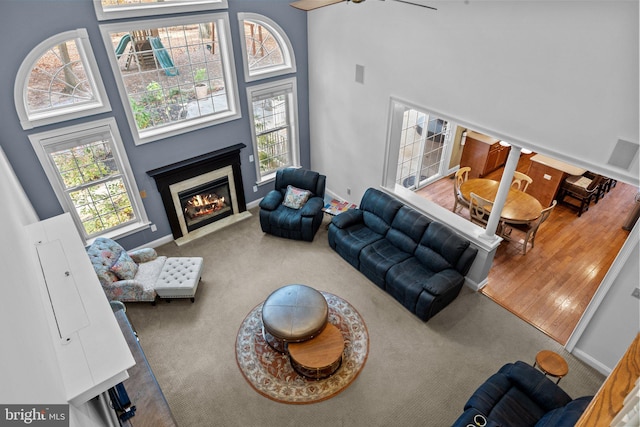 living room featuring a high ceiling, carpet, and ceiling fan