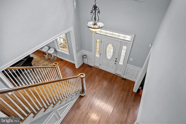 foyer entrance featuring a towering ceiling and hardwood / wood-style flooring