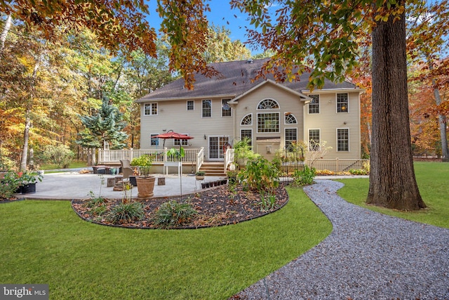 rear view of house featuring a patio and a lawn