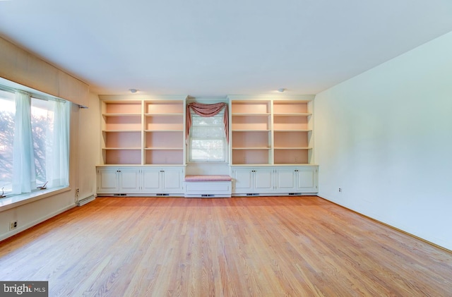 unfurnished living room featuring light hardwood / wood-style floors and a baseboard heating unit