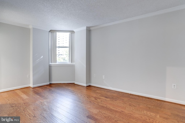 unfurnished room featuring ornamental molding, a textured ceiling, and wood-type flooring