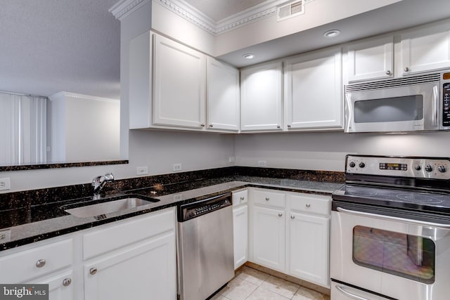 kitchen with appliances with stainless steel finishes, ornamental molding, sink, and white cabinetry