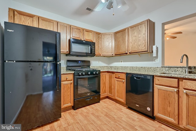 kitchen with light hardwood / wood-style floors, black appliances, sink, and ceiling fan