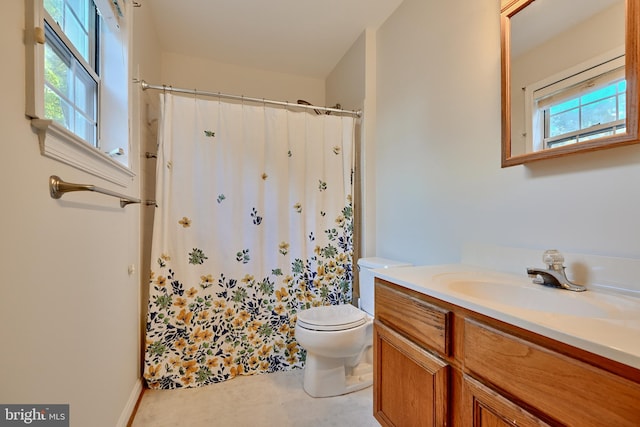 bathroom featuring vanity, toilet, a wealth of natural light, and curtained shower