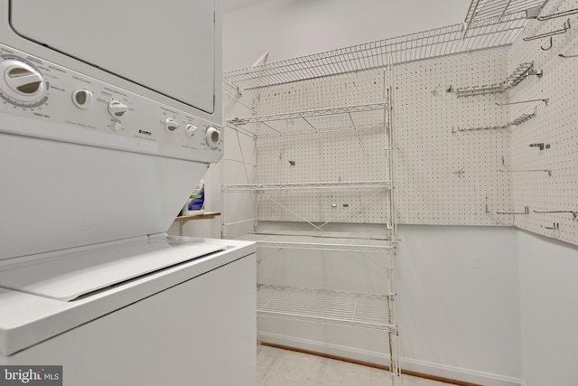 washroom featuring stacked washer / drying machine