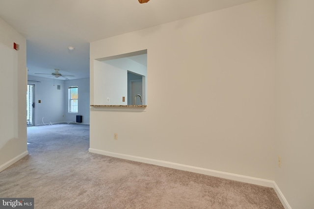 spare room featuring light carpet and ceiling fan