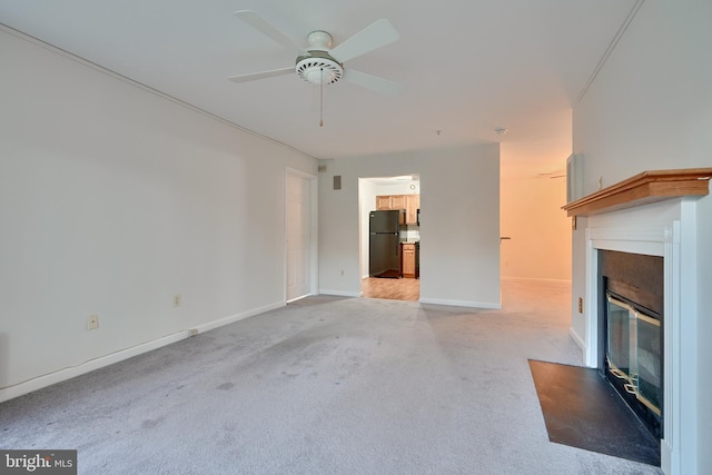 unfurnished living room featuring light carpet and ceiling fan