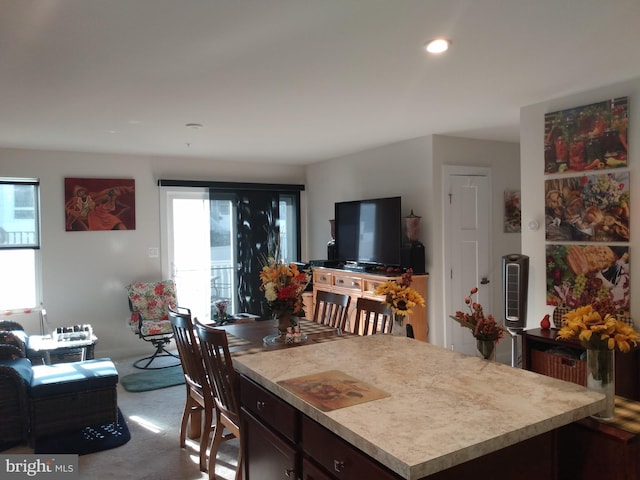 kitchen with a kitchen island, dark brown cabinetry, and carpet floors