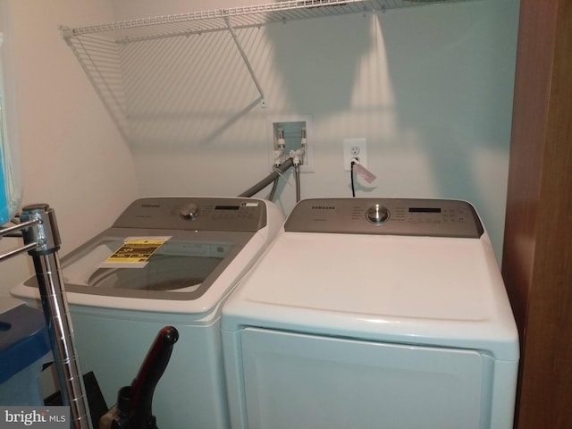 clothes washing area with washing machine and dryer