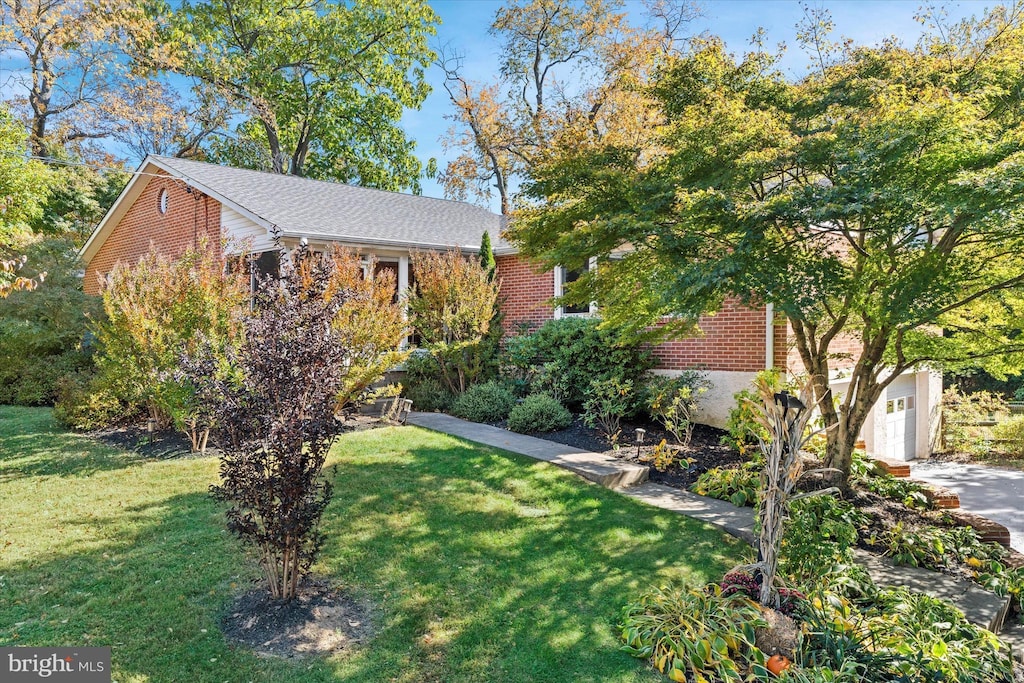 obstructed view of property with a front lawn and a garage