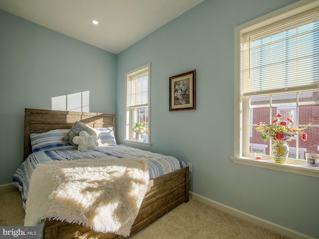 bedroom featuring multiple windows and light carpet