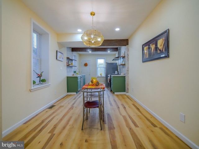 dining space with sink, an inviting chandelier, and light hardwood / wood-style floors