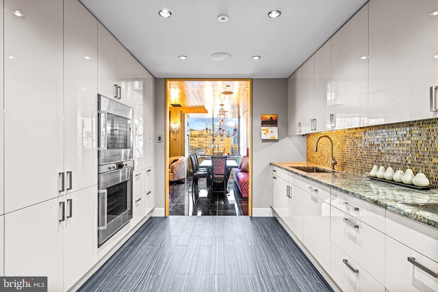 kitchen with sink, white cabinetry, and stainless steel appliances