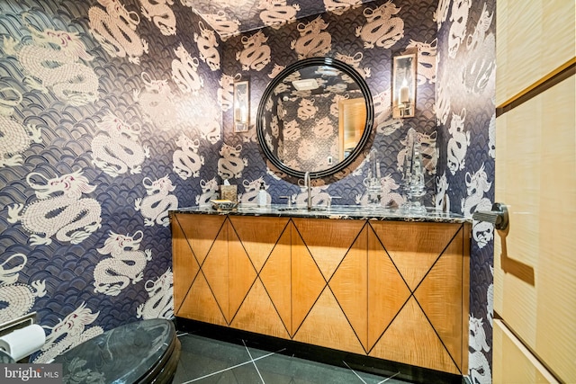 bathroom with toilet, vanity, and tile patterned floors