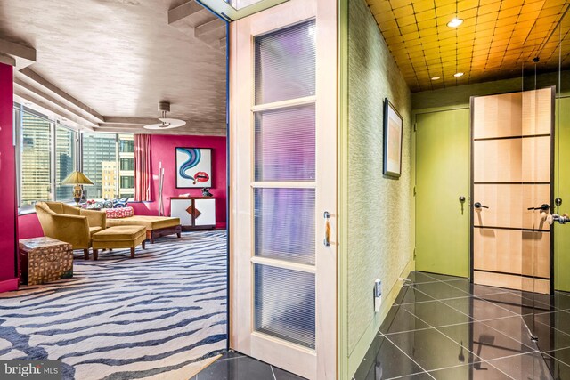 hall featuring dark tile patterned flooring