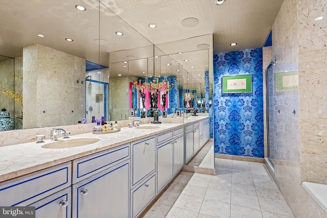 bathroom featuring a shower with door, vanity, and tile walls