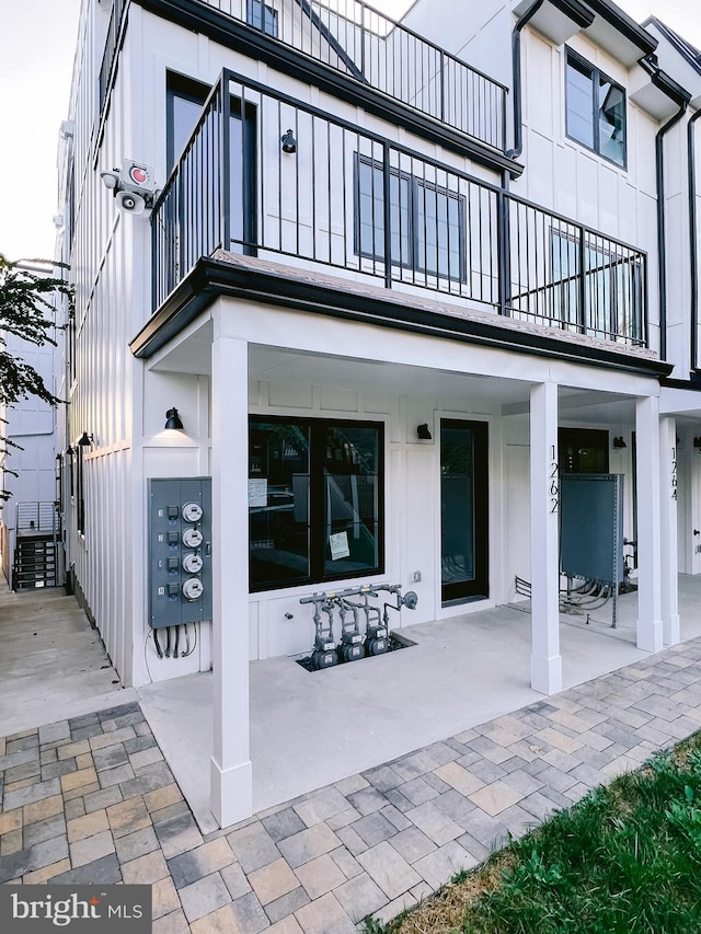 rear view of property with a patio and a balcony