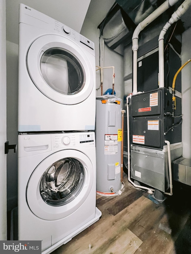 washroom with water heater, stacked washer and dryer, and hardwood / wood-style flooring