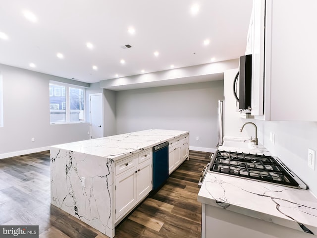 kitchen with a kitchen island, dark hardwood / wood-style floors, white cabinetry, appliances with stainless steel finishes, and light stone counters